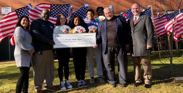 Students, Staff, and Veterans holding big check