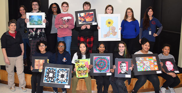 Twelve students Holding Artwork