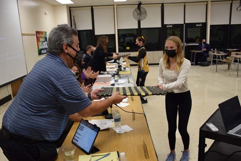 Student giving gift to board member