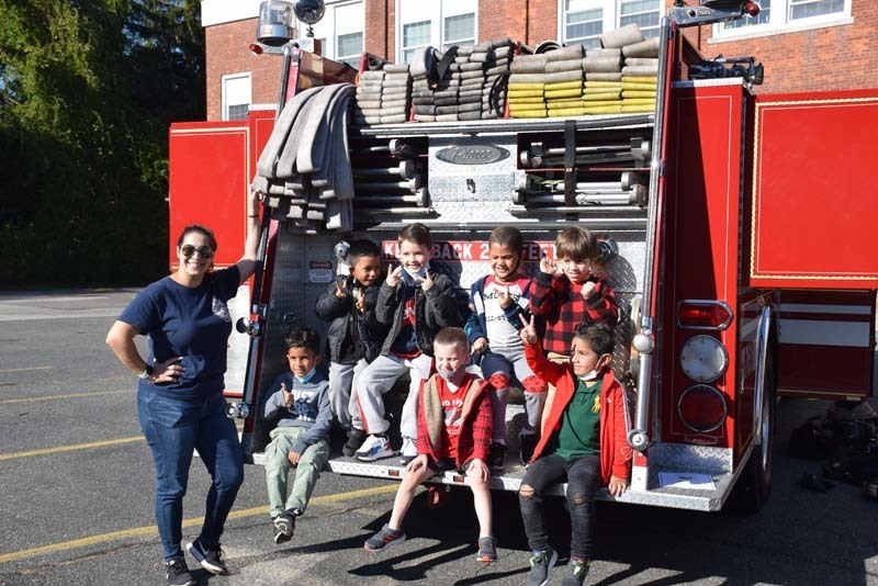 students sitting on the back of a fire truck