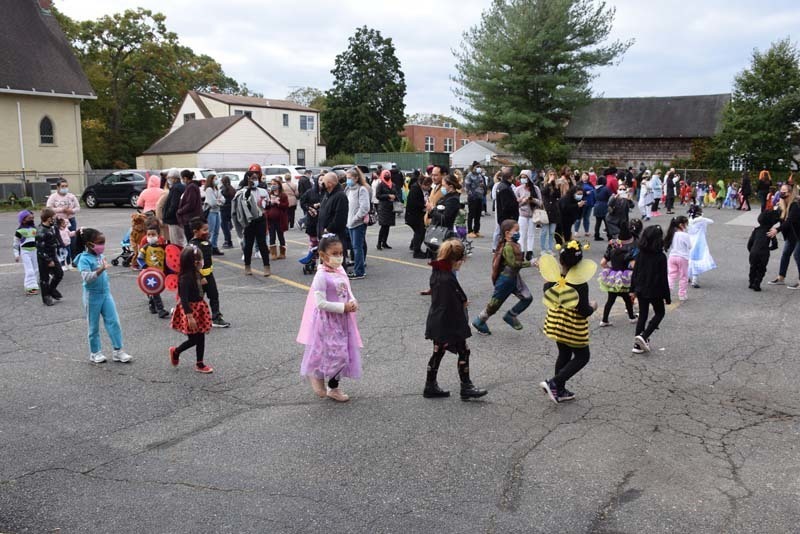 Students Walking During Halloween Parade While Staff and Parents Watch