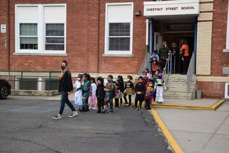 Students Walking During Halloween Parade While Staff and Parents Watch