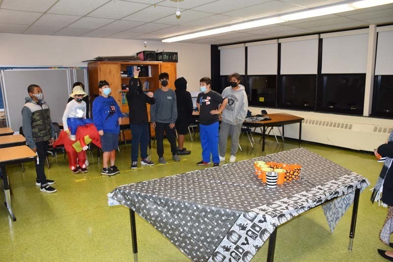 Student tossed ping pong balls into cups as part of the spooky challenge.