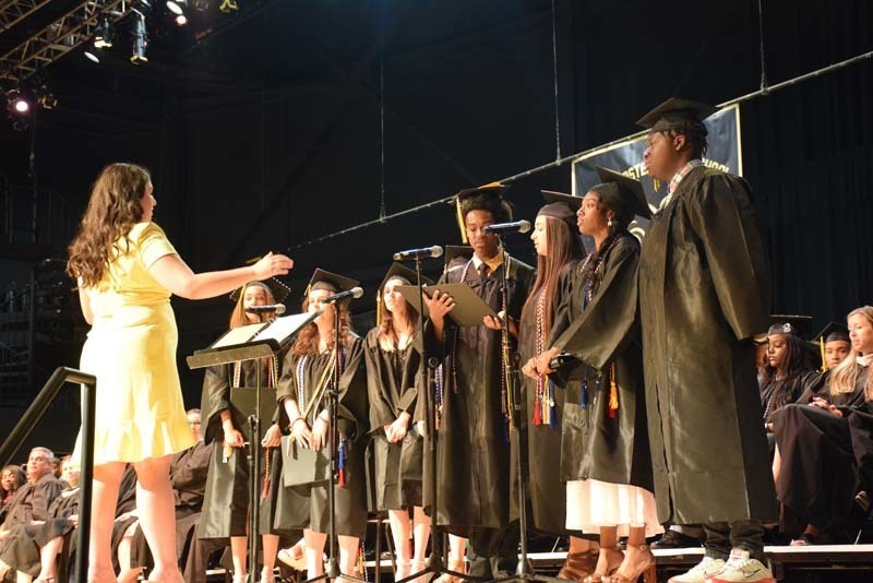 Graduates performing a song on stage